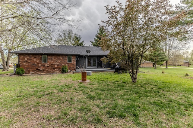 exterior space featuring a sunroom, a front yard, and brick siding