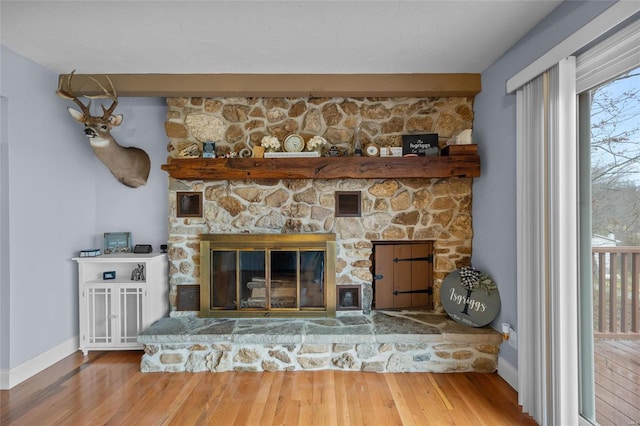 interior details with visible vents, baseboards, wood finished floors, and a fireplace