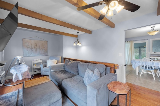 living room with beamed ceiling, radiator, wood finished floors, and ceiling fan