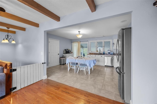 dining area with beamed ceiling and light wood-type flooring