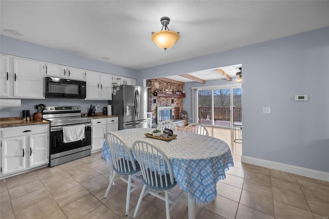 kitchen featuring stainless steel appliances, baseboards, light tile patterned flooring, and white cabinetry