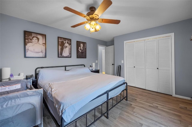 bedroom featuring baseboards, a closet, light wood finished floors, and ceiling fan