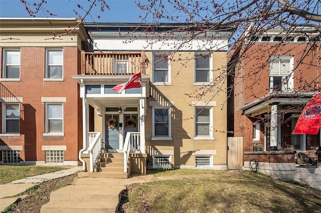 multi unit property featuring brick siding and a balcony