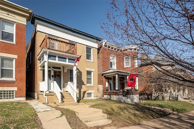 view of property with a balcony and brick siding