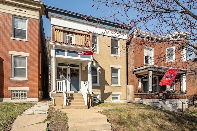 townhome / multi-family property with brick siding and a balcony
