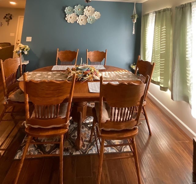dining room with baseboards, a notable chandelier, and wood finished floors