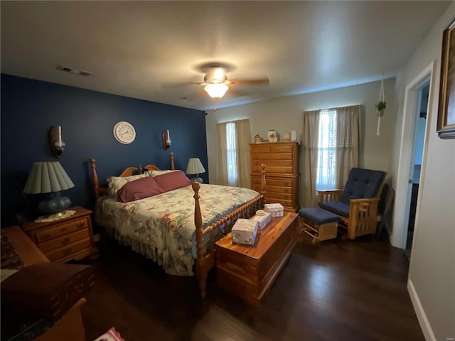 bedroom featuring a ceiling fan, wood finished floors, baseboards, and visible vents