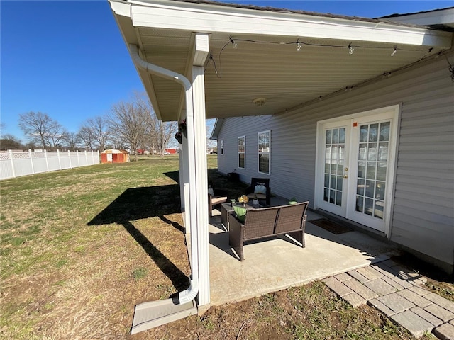 view of patio / terrace with a shed, an outbuilding, fence, and french doors