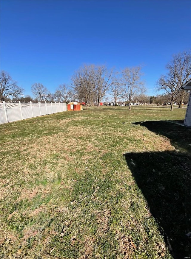 view of yard with an outdoor structure, a storage unit, and fence
