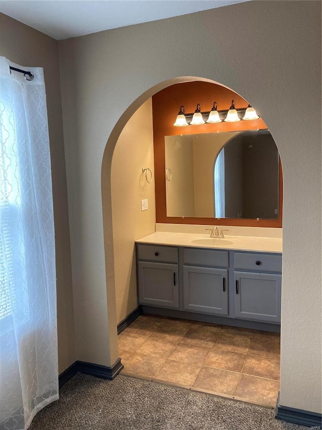 bathroom with a shower with shower curtain, baseboards, and vanity