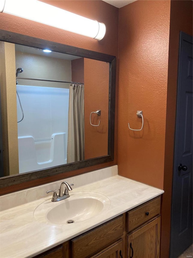 bathroom with a shower with shower curtain and vanity