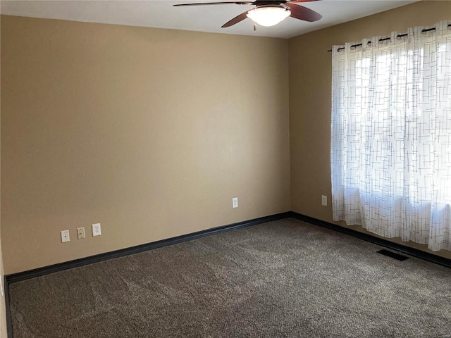 carpeted spare room featuring visible vents, baseboards, and a ceiling fan