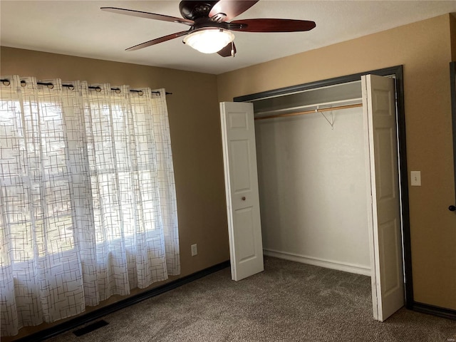 unfurnished bedroom featuring baseboards, visible vents, ceiling fan, a closet, and carpet flooring