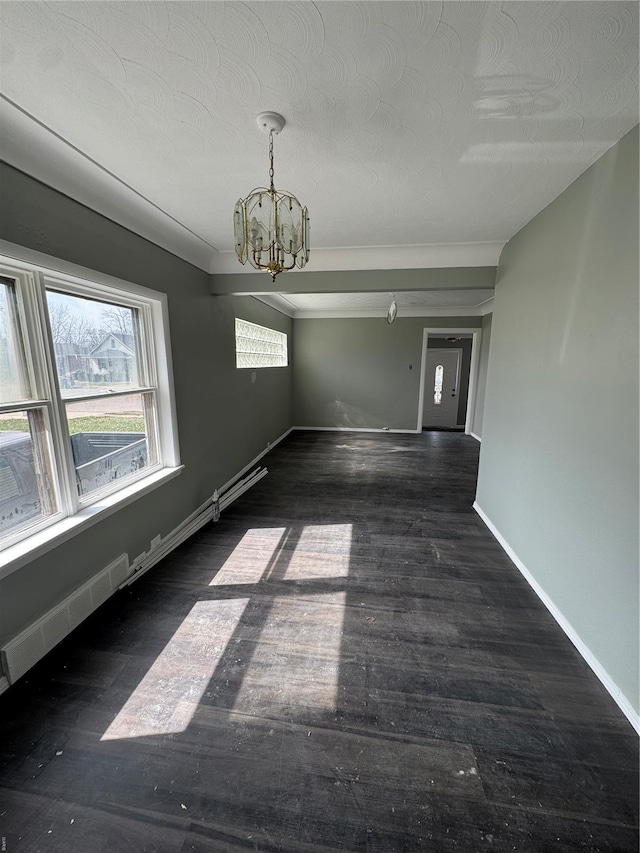 spare room with baseboards, a textured ceiling, wood finished floors, and a notable chandelier
