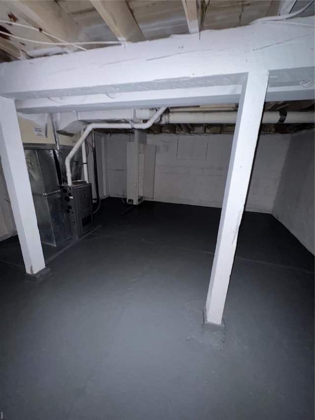 unfinished basement featuring heating unit