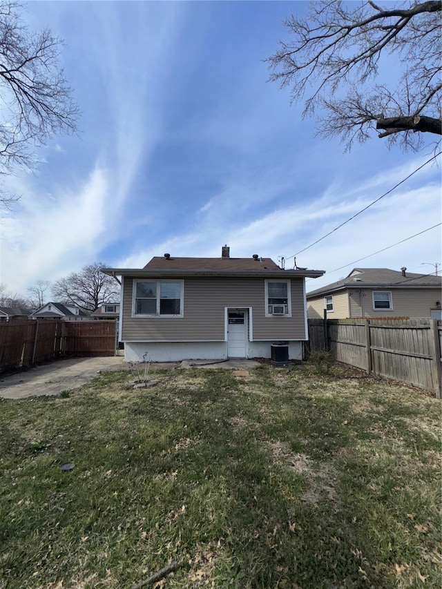 back of house with a fenced backyard, a lawn, and a patio