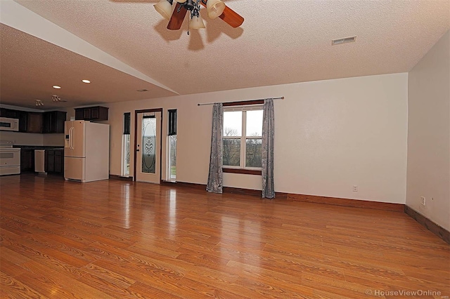 unfurnished living room featuring ceiling fan, baseboards, a textured ceiling, and wood finished floors