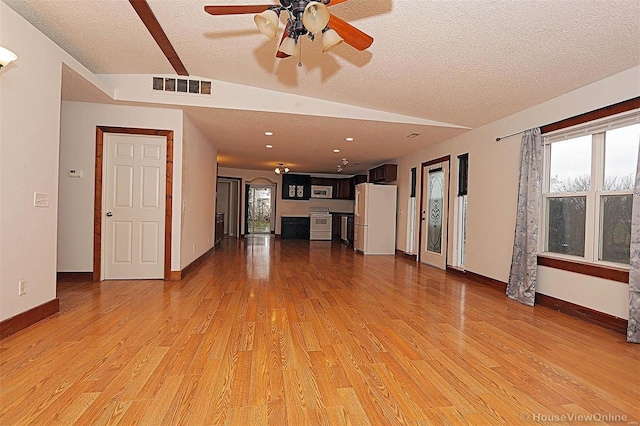 unfurnished living room with a ceiling fan, baseboards, visible vents, a textured ceiling, and light wood-type flooring