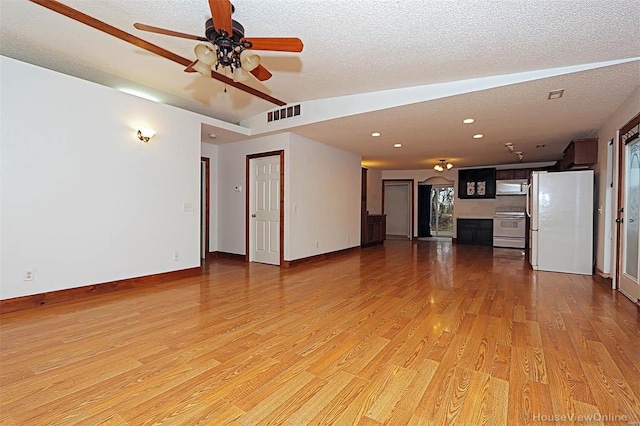 unfurnished living room with ceiling fan, visible vents, light wood-type flooring, and a textured ceiling