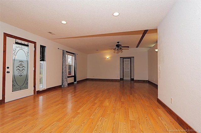 unfurnished room with light wood-style flooring, a ceiling fan, baseboards, and a textured ceiling