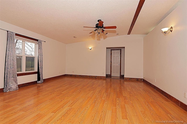 spare room featuring a ceiling fan, baseboards, light wood finished floors, and a textured ceiling