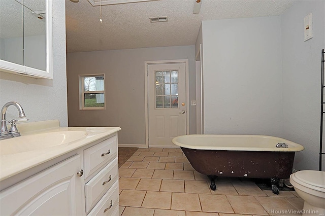 bathroom with visible vents, a freestanding bath, vanity, tile patterned floors, and a textured ceiling