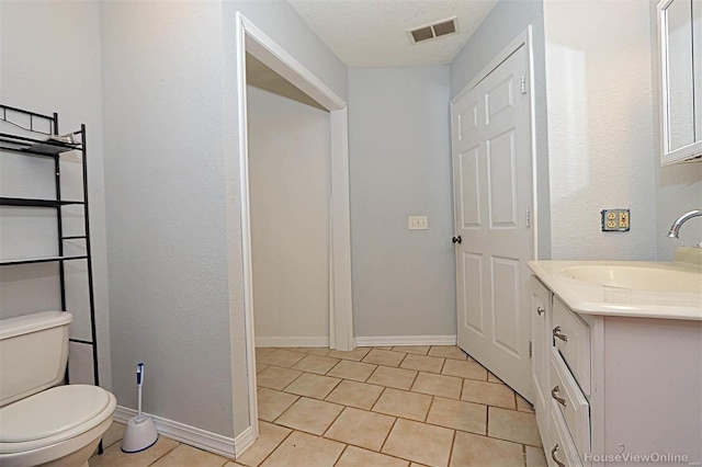 bathroom featuring tile patterned floors, visible vents, toilet, baseboards, and vanity