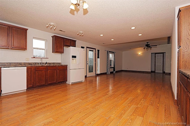 kitchen with light wood-style flooring, a ceiling fan, a sink, a textured ceiling, and white appliances