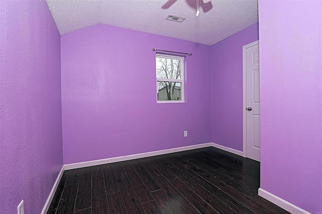 spare room featuring visible vents, dark wood-type flooring, a ceiling fan, a textured ceiling, and baseboards