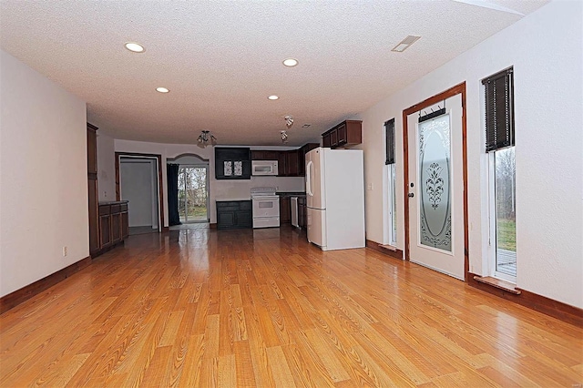 unfurnished living room with visible vents, light wood-style flooring, a textured ceiling, recessed lighting, and baseboards