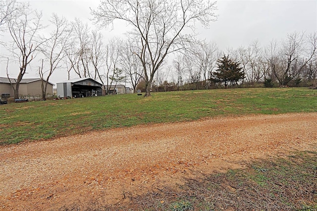 view of yard with a detached carport, an outbuilding, and an outdoor structure