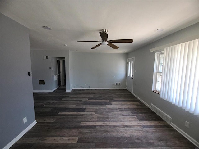 unfurnished living room with visible vents, baseboards, dark wood-type flooring, and ceiling fan