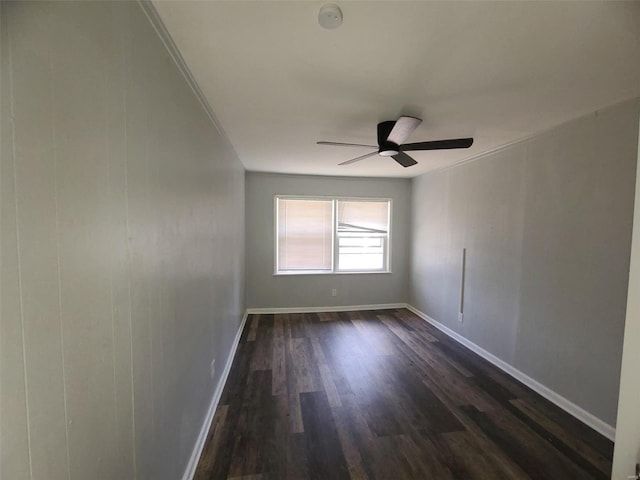 empty room with baseboards, dark wood-style flooring, and ceiling fan