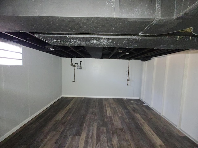 basement with baseboards and dark wood-style flooring