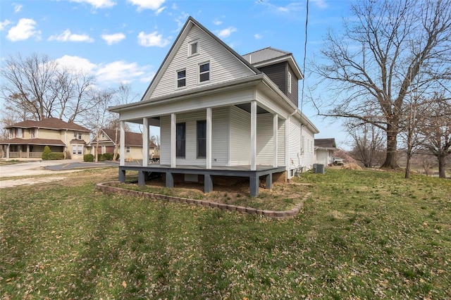 view of front of property with central AC unit, driveway, a porch, and a front yard