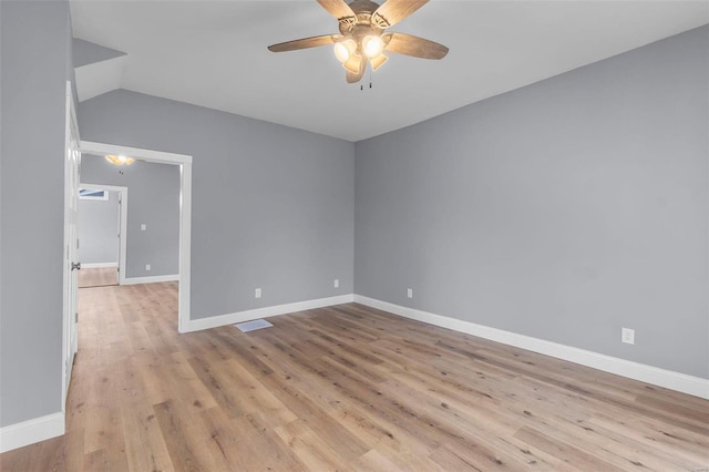 unfurnished room with lofted ceiling, baseboards, light wood-style floors, and a ceiling fan