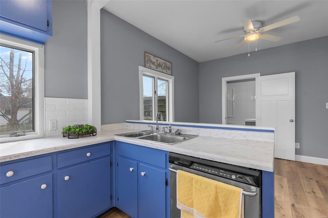 kitchen featuring a sink, blue cabinets, dishwasher, and light countertops