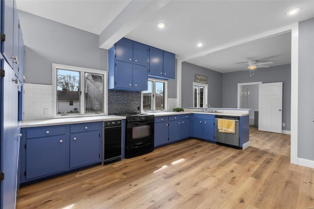 kitchen with black electric range, blue cabinetry, stainless steel dishwasher, a peninsula, and light countertops