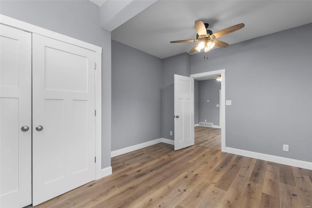 unfurnished bedroom with visible vents, a closet, light wood-style floors, baseboards, and ceiling fan