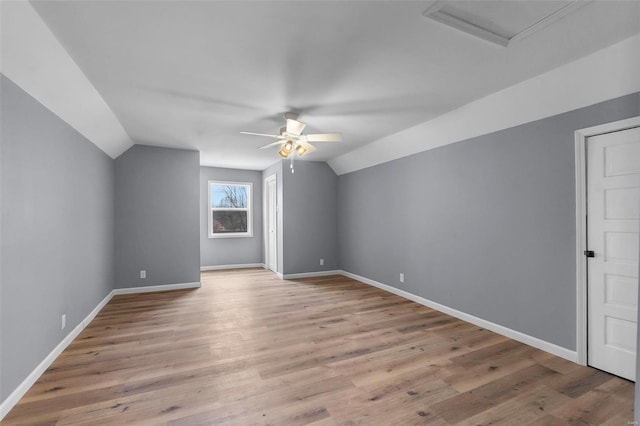 bonus room featuring baseboards, ceiling fan, vaulted ceiling, and light wood finished floors