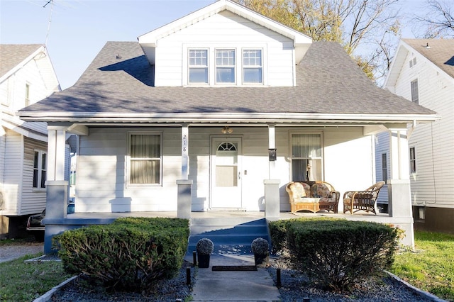 bungalow featuring covered porch and roof with shingles