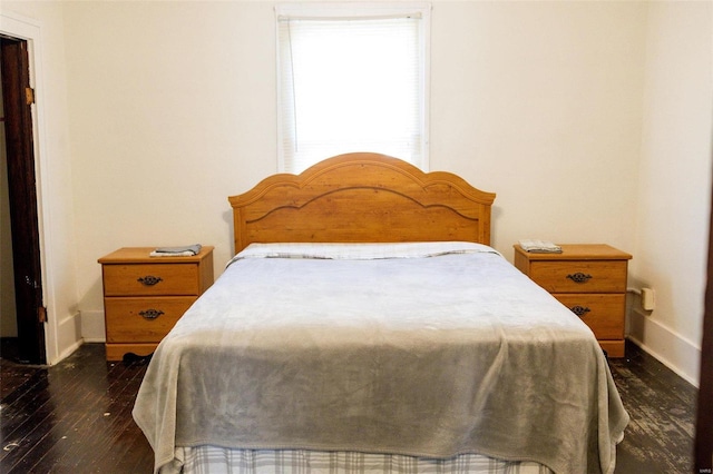 bedroom with baseboards and dark wood-style floors