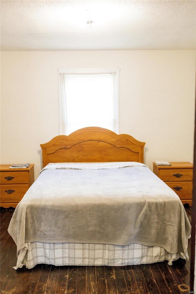 bedroom featuring a textured ceiling and wood finished floors