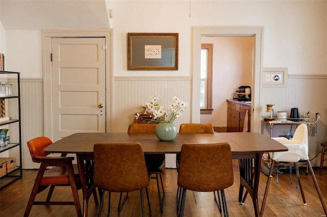 dining room with wainscoting and wood finished floors