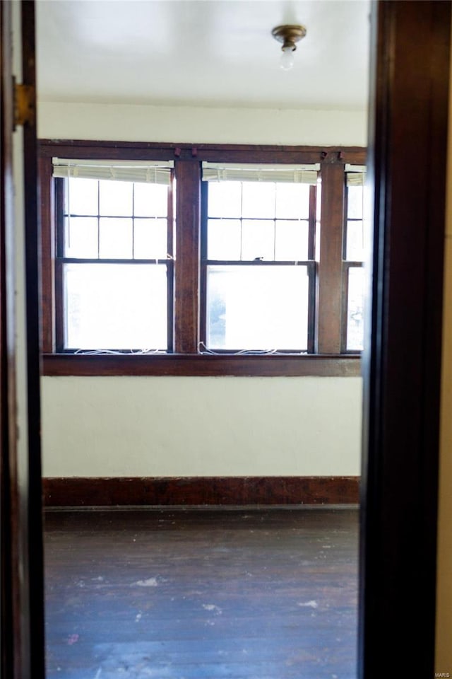 unfurnished room featuring a healthy amount of sunlight and baseboards