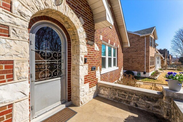 doorway to property with brick siding