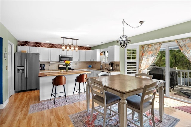 dining area with an inviting chandelier and light wood-style flooring