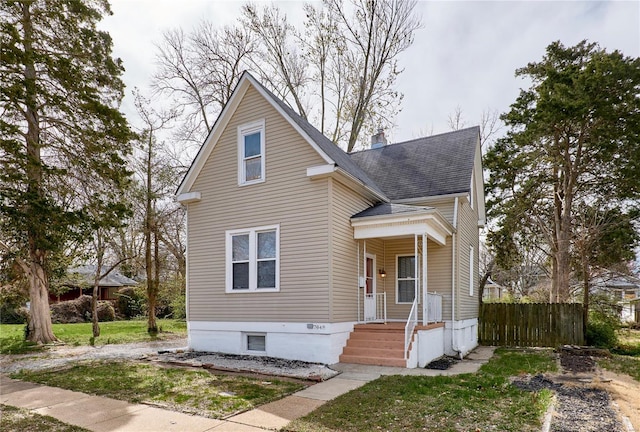 traditional-style home with a shingled roof and fence