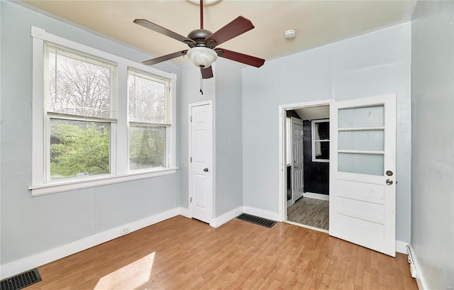 unfurnished bedroom with baseboards, ensuite bathroom, visible vents, and light wood finished floors