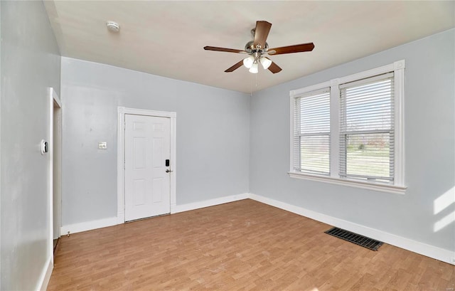 unfurnished room with baseboards, visible vents, a ceiling fan, and light wood finished floors